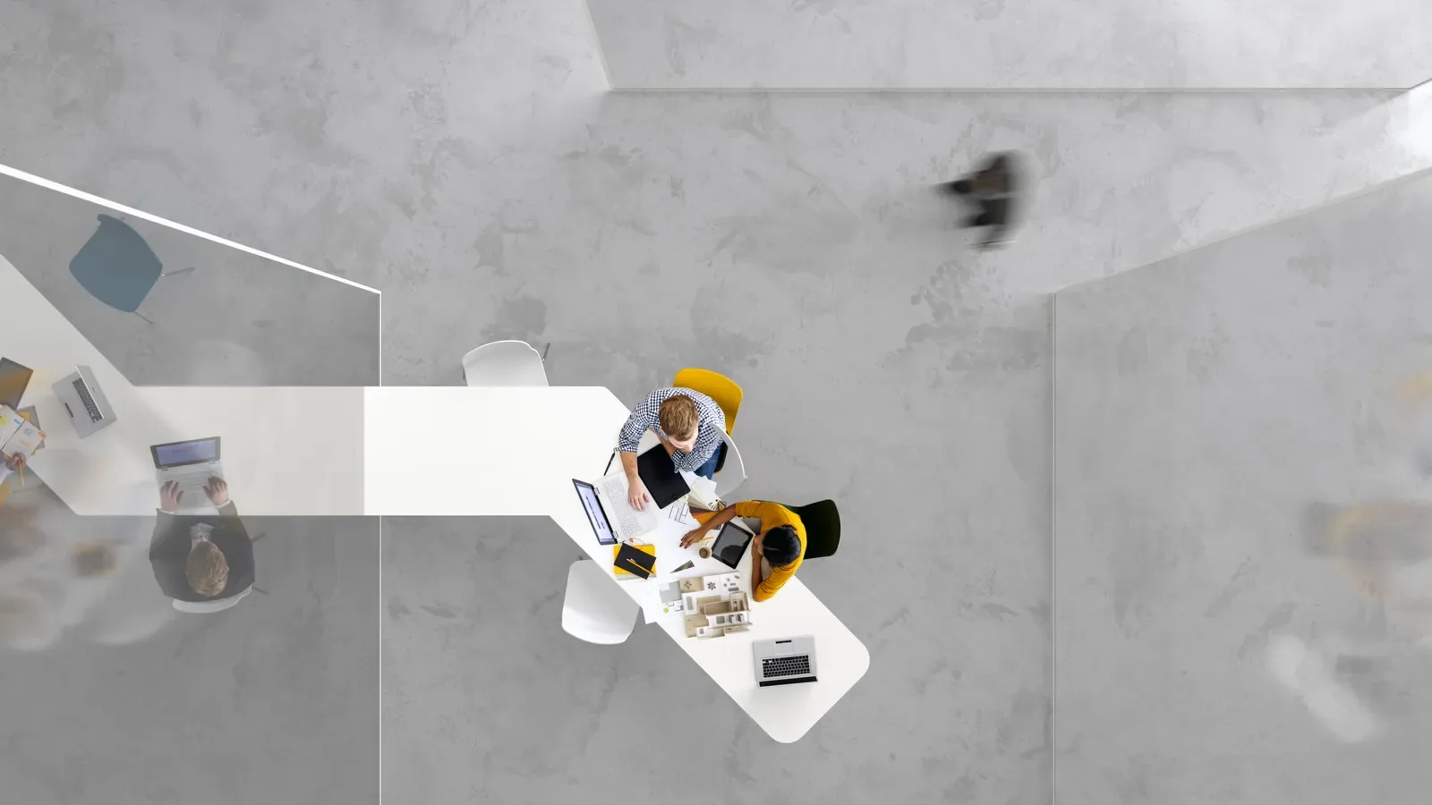 An overhead view of colleagues working together around a table in a spacious office