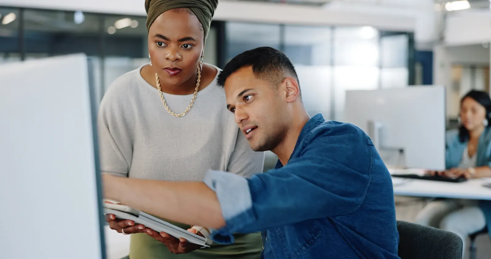 Two colleagues reviewing a business process together on a tablet